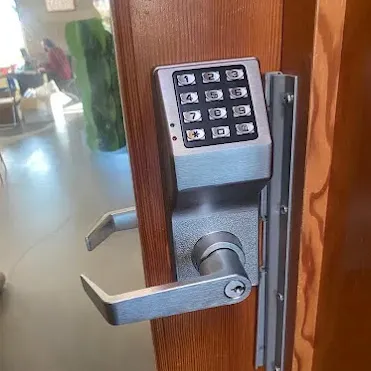 Digital keypad door lock on wooden door.