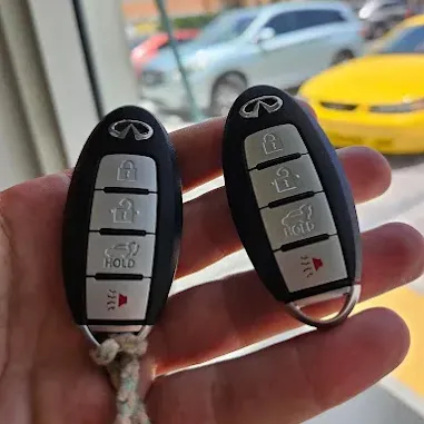 Pair of car key fobs held in hand.